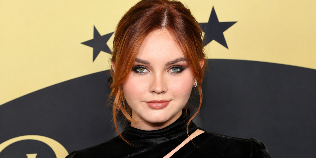 Liana Liberato posing in a black velvet outfit at a red carpet event