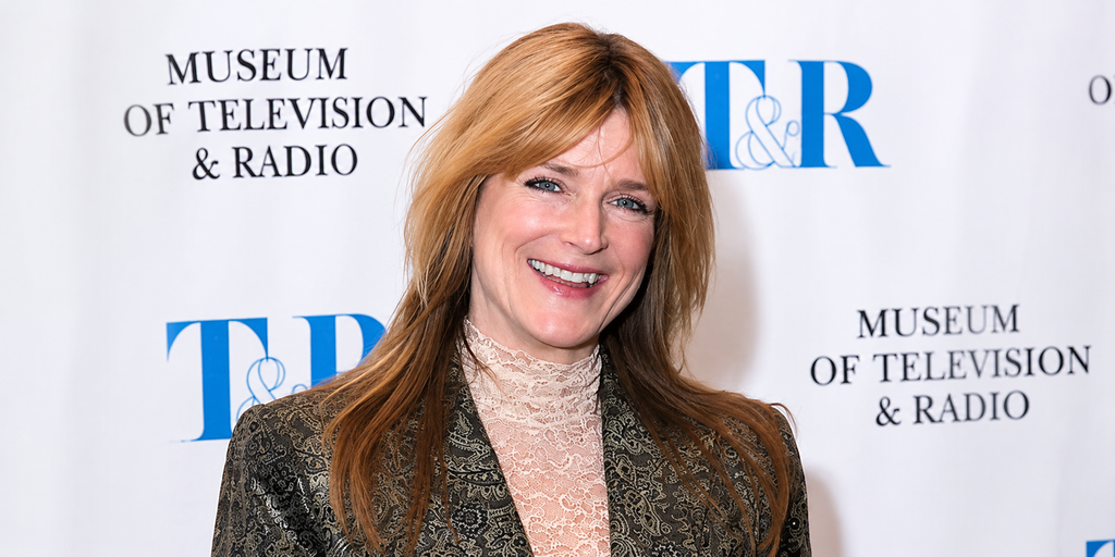 Susan Olson smiling in a patterned blazer at a television and radio event