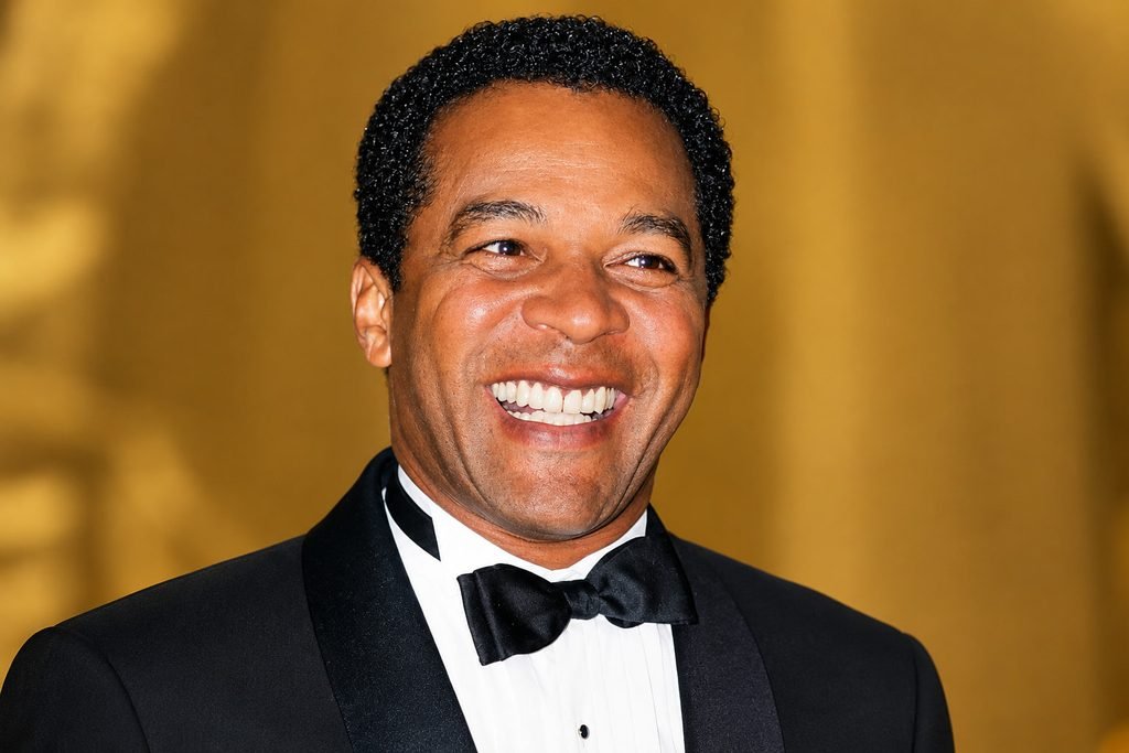 Clifton Davis smiling in a black tuxedo with a white shirt and black bow tie