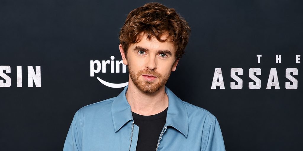 Freddie Highmore wearing a blue jacket at a promotional event
