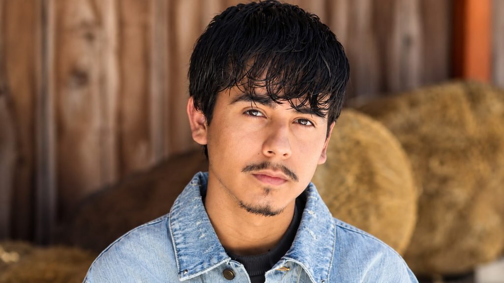 Ivan Cornejo wearing a light blue denim jacket against a rustic background