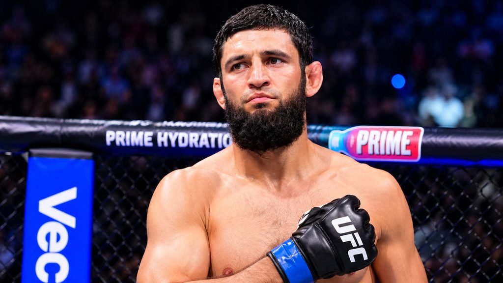 Khamzat Chimaev posing inside the UFC octagon wearing black UFC gloves