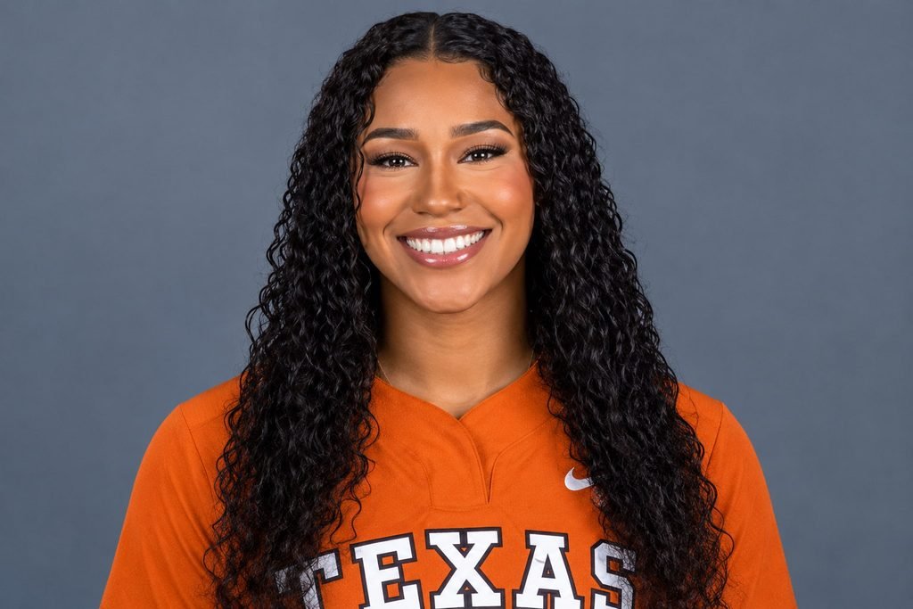 Mia Scott smiling in an orange Texas jersey with long curly black hair.
