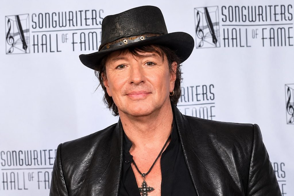 Richie Sambora wearing a black cowboy hat and leather jacket at an event